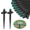 Garden irrigation system with black spikes and green nozzles on a white background.