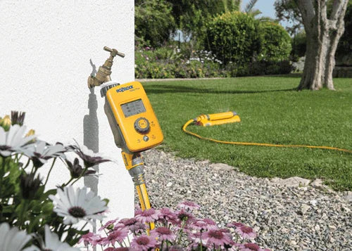 Gardening tool with hose on a grassy background