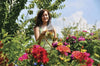 Woman standing among flowers and trees using a Hozelock 2292 Spray