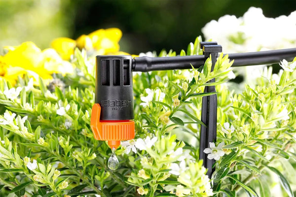 Claber Gardening tool with orange nozzle on a green plant background