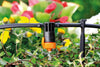 Claber Garden irrigation system with orange nozzle on a blurred garden background