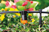 Claber Garden irrigation system with orange nozzle on a blurred garden background