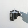 Claber 90844 Bluetooth Rain Sensor. Black outdoor light fixture on a white wall