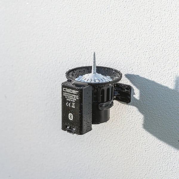 Claber 90844 Bluetooth Rain Sensor. Black outdoor light fixture on a white wall