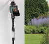 Claber timer on a white wall with grass in the background