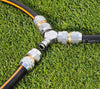 Two garden hoses with metallic connectors on a grass background
