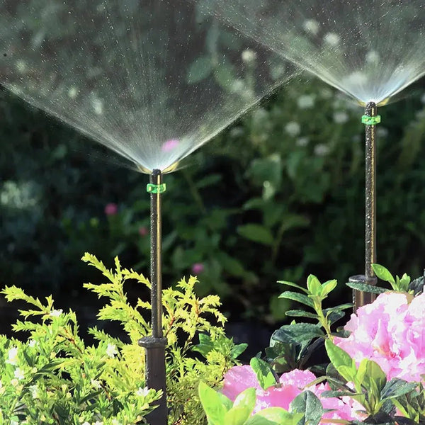 Garden sprinkler watering plants with a blurred garden background