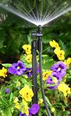 Antelco Sprinkler system with hose and spray head in a garden with flowers