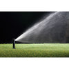 Sprinkler spraying water onto grass with a black background
