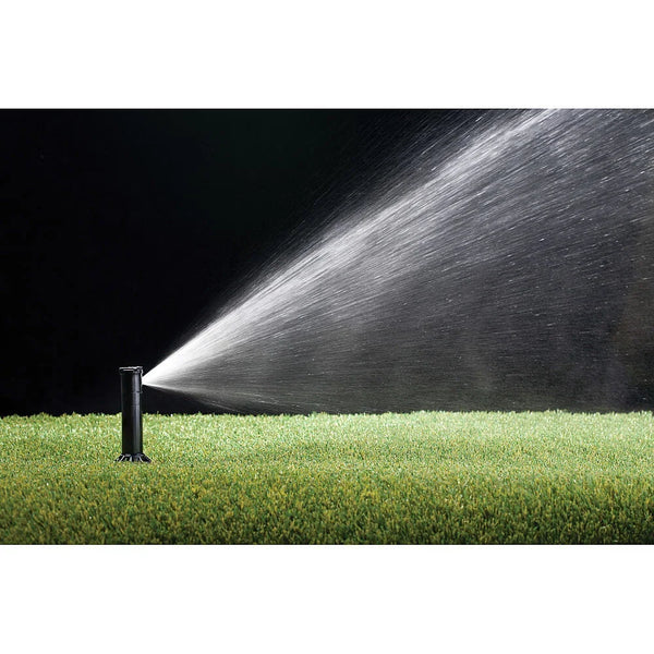 Sprinkler spraying water onto grass with a black background
