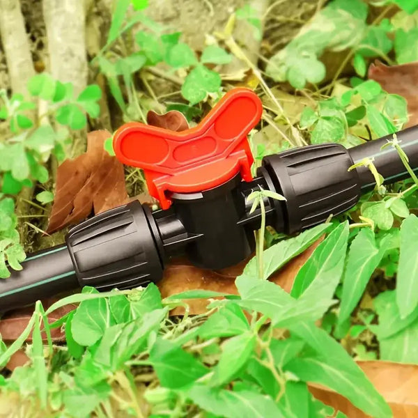 Garden irrigation valve with red handle in a natural setting