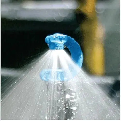 Blue spray nozzle releasing water in a blurred outdoor setting