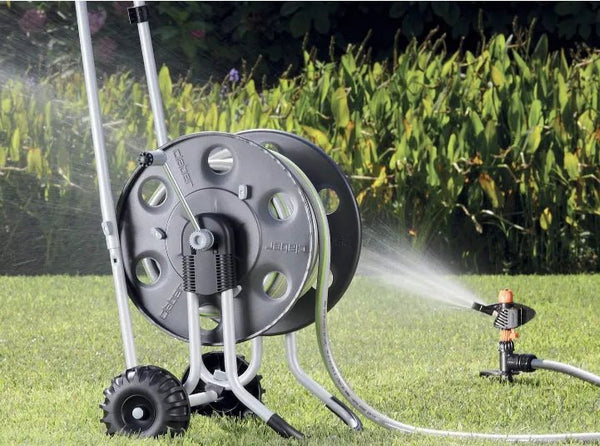 Claber Metal 60 Hose reel on grass with sprinkler in the background