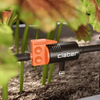 Claber garden tool with orange and black design in a garden setting