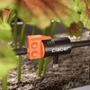 Claber garden tool with orange and black design in a garden setting