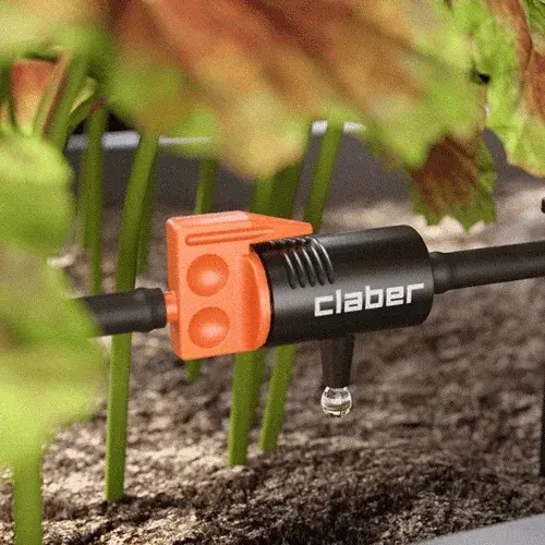 Claber garden tool with orange and black design in a garden setting