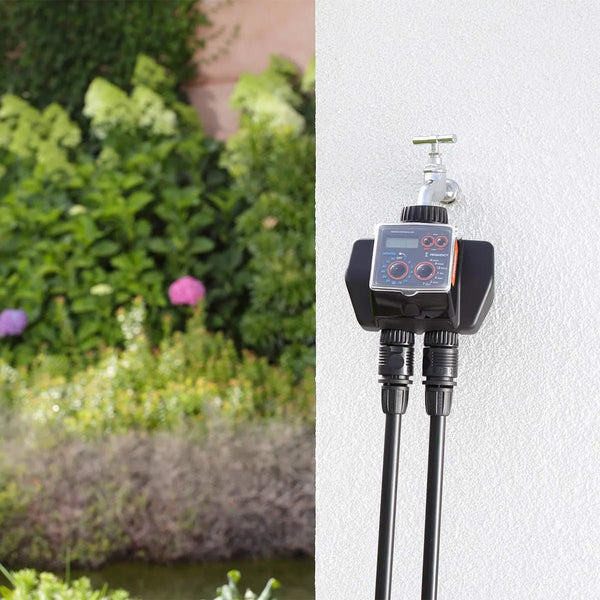 Claber Dual Select 8488 Garden irrigation system with two nozzles attached, set against a garden background.