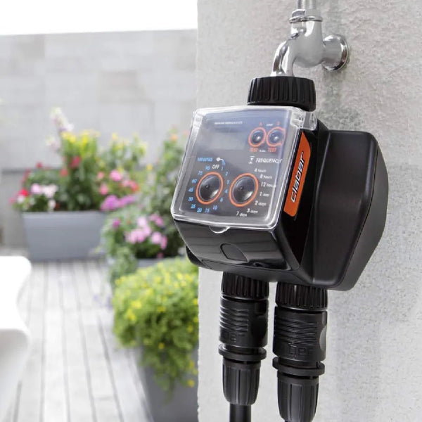 Claber Gardening controller attached to a garden faucet with plants in the background