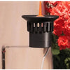 Claber rain sensor on wall bracket with flowers in the background