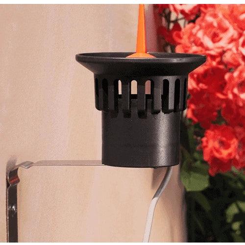 Claber rain sensor on wall bracket with flowers in the background