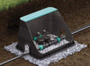 Garden irrigation system with sprinkler on a bed of small stones.
