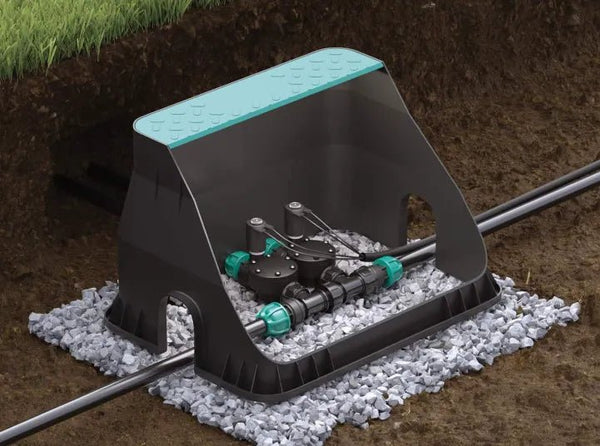 Garden irrigation system with sprinkler on a bed of small stones.