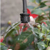 Black sprinkler head watering plants with a blurred background