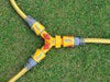 Three garden hoses with connectors on a grass background
