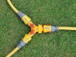 Three garden hoses with connectors on a grass background