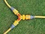 Three garden hoses with connectors on a grass background