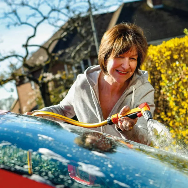 Woman washing a car with a hozelock 2675 spray gun outdoors