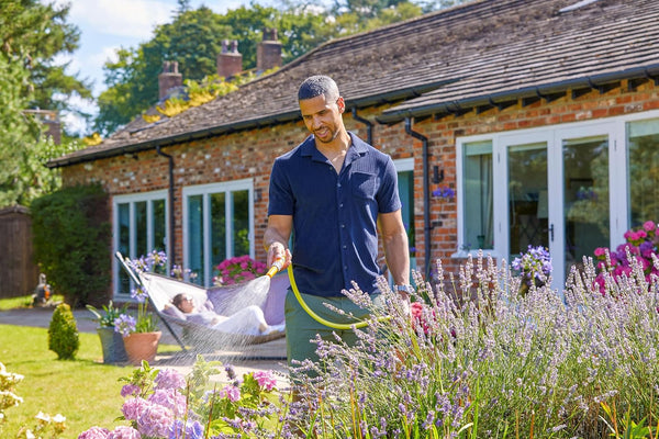 Man standing in a garden with lavender and a house in the background