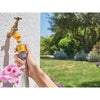 Hand holding a garden hose with a nozzle, transitioning to a garden scene.