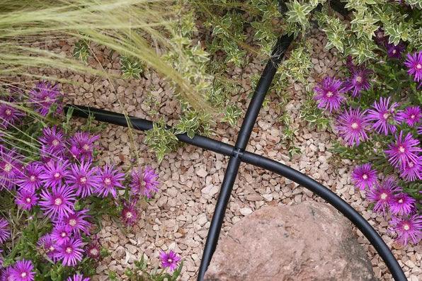 Drip irrigation cross connector in flowerbed