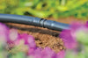 Hozelock 2768 Drip irrigation system in a garden with flowers and soil.