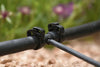 Close-up of a black irrigation pipe with round zip style connectors