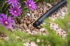 Irrigation end stop in pipe over gravel with flowers