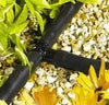 Drip irrigation system with tee connectors flowers and gravel in the background