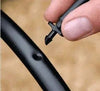Close-up of a hand inserting an irrigation adapter into supply hose