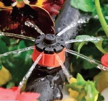 Close-up of a garden sprinkler with plants in the background