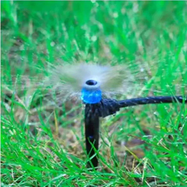 Sprinkler head spraying water on grass