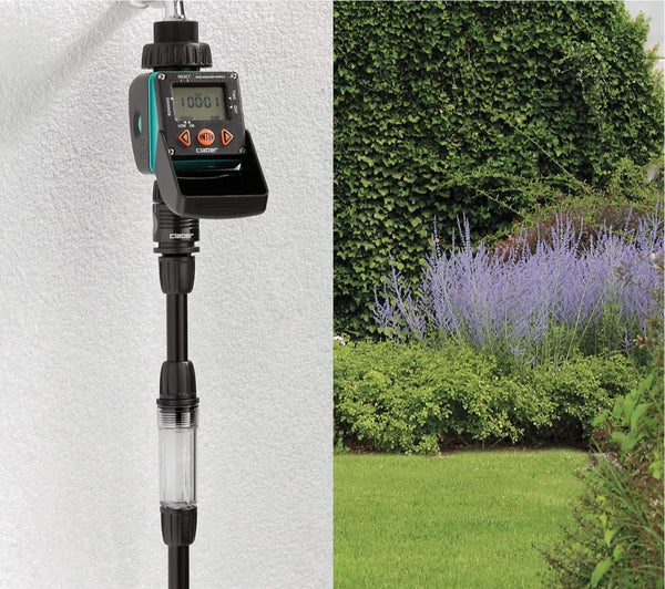 Claber timer on a white wall with grass in the background