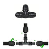 Black plastic plumbing fitting assembly with green arrows indicating connections on a white background