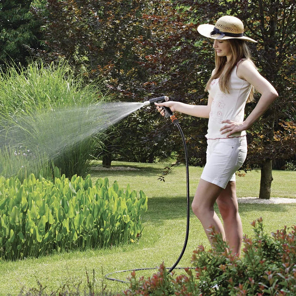 Woman watering plants in a garden using a Claber Metal-Jet Plus 9567