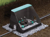 Garden irrigation system with sprinkler on a bed of small stones.