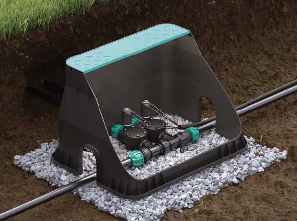 Garden irrigation system with sprinkler on a bed of small stones.