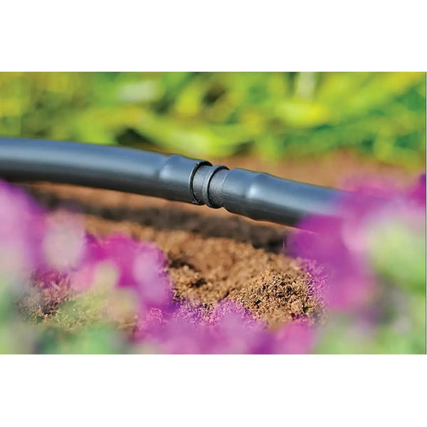 Drip irrigation system with plants in the background